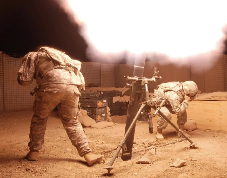 Mortar team firing at night during deployment, muzzle flash lighting the position